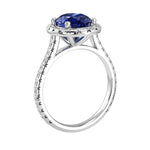 Blue sapphire oval lab created gemstone ring on hand, modern luxury engagement ring with diamond band