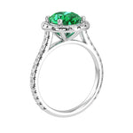 Colombian emerald oval ring on hand with diamond band, luxury lab grown emerald ring